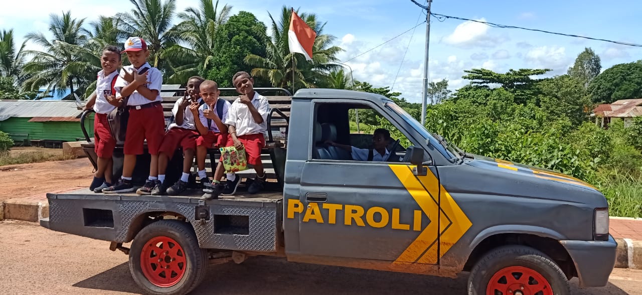 Anak murid di SD Sota yang sedang dibawa polisi dengan mobil menuju ke sekolah – Surya Papua/IST