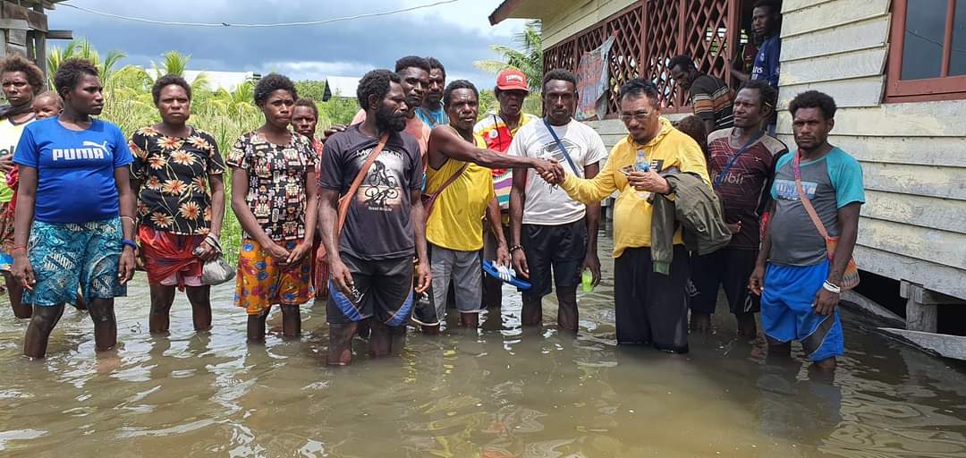 Wakil Ketua II DPRD Kabupaten Merauke, Dominikus Ulukyaan bersama masyarakat di salah satu kampung di Distrik Waan sedang berada di tengah air pasang yang masuk di perumahan – Surya Papua/IST