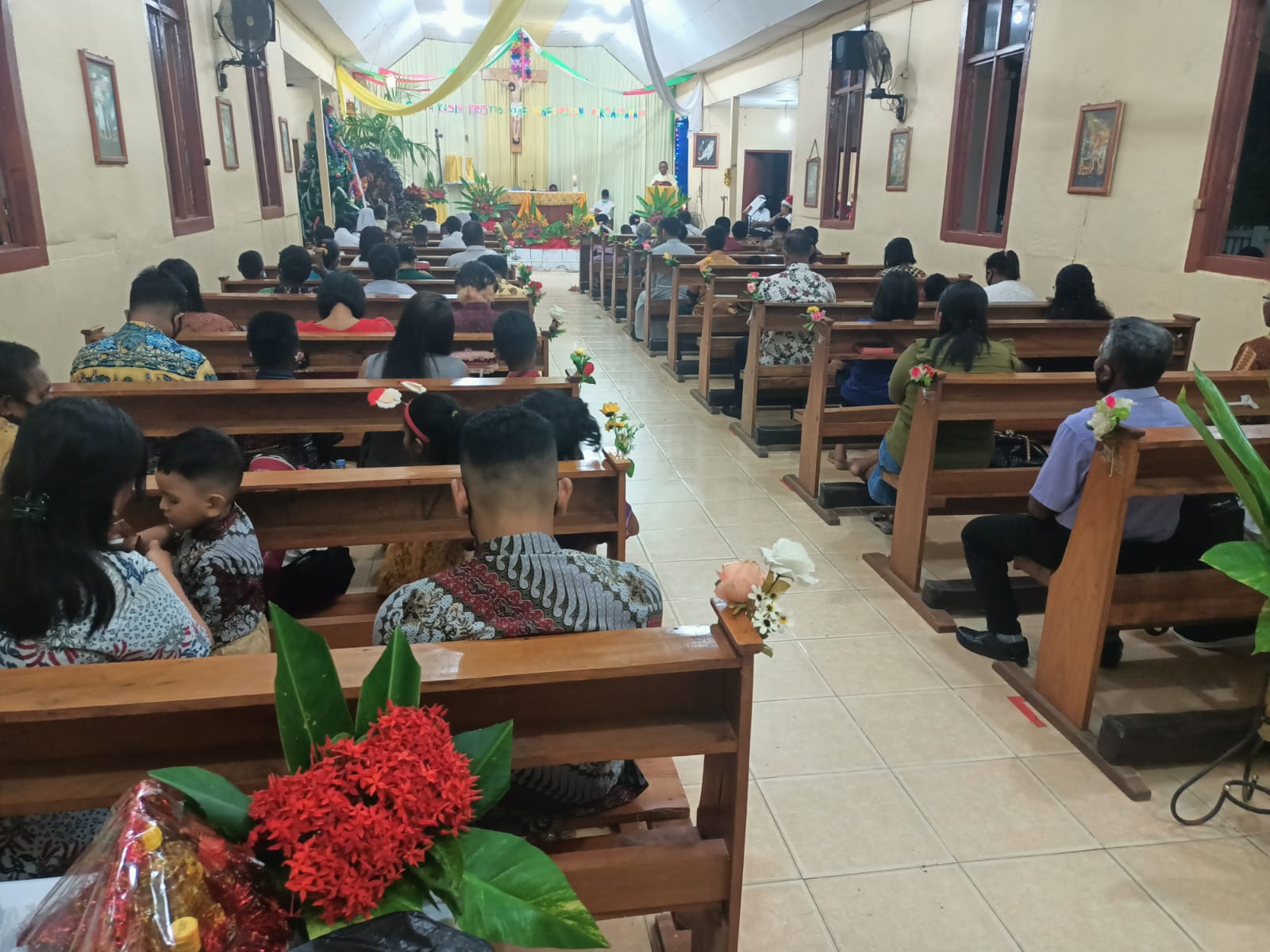 Umat Katolik di Gereja Santa Theresia Buti sedang mendengar khobtah Pastor Pius Oematan, Pr – Surya Papua/Frans Kobun