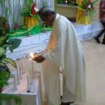 Pastor Paroki Santa Theresia Buti, Romo Pius Oematan, Pr sedang membakar lilin – Surya Papua/Frans Kobun