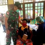Babinsa sedang mendampingi salah seorag ibu di Kampung Toghom untuk siap divaksin – Surya Papua/IST