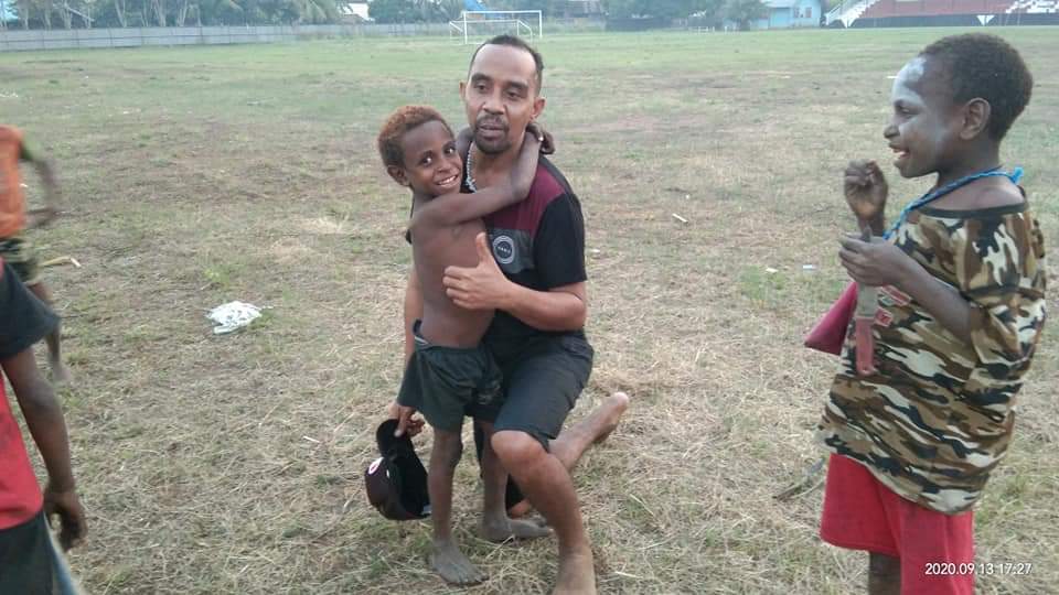 Ketua Asrama Putra dan Putri Anak 3 T SMA Negeri Plus 1 Merauke, Polikarpus Boli Kobun saat memeluk seorang anak Papua– Surya Papua/IST