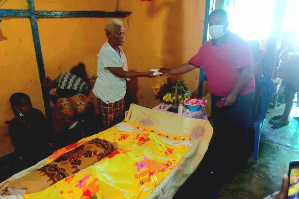 Staf Bupati Merauke, Florianus Senda sedang menyerahkan bantuan kepada keluarga almarhumah – Surya Papua/IST