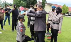 Salah seorang bintara remaja Polri sedang mandi kembang yang dilakukan Wabup Merauke, H. Riduwan – Surya Papua/Yulianus Bwariat
