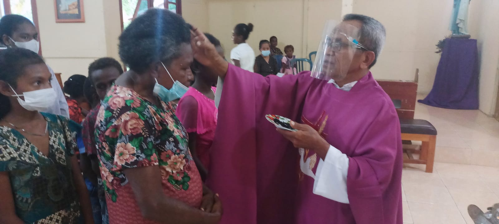 Pastor Pius Oematan, Pr sedang menandai abu di dahi salah seorang umat – Surya Papua/Frans Kobun