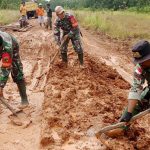 Beberapa anggota sedang mengangkut lumpur di bada jalan yang rusak – Surya Papua/IST