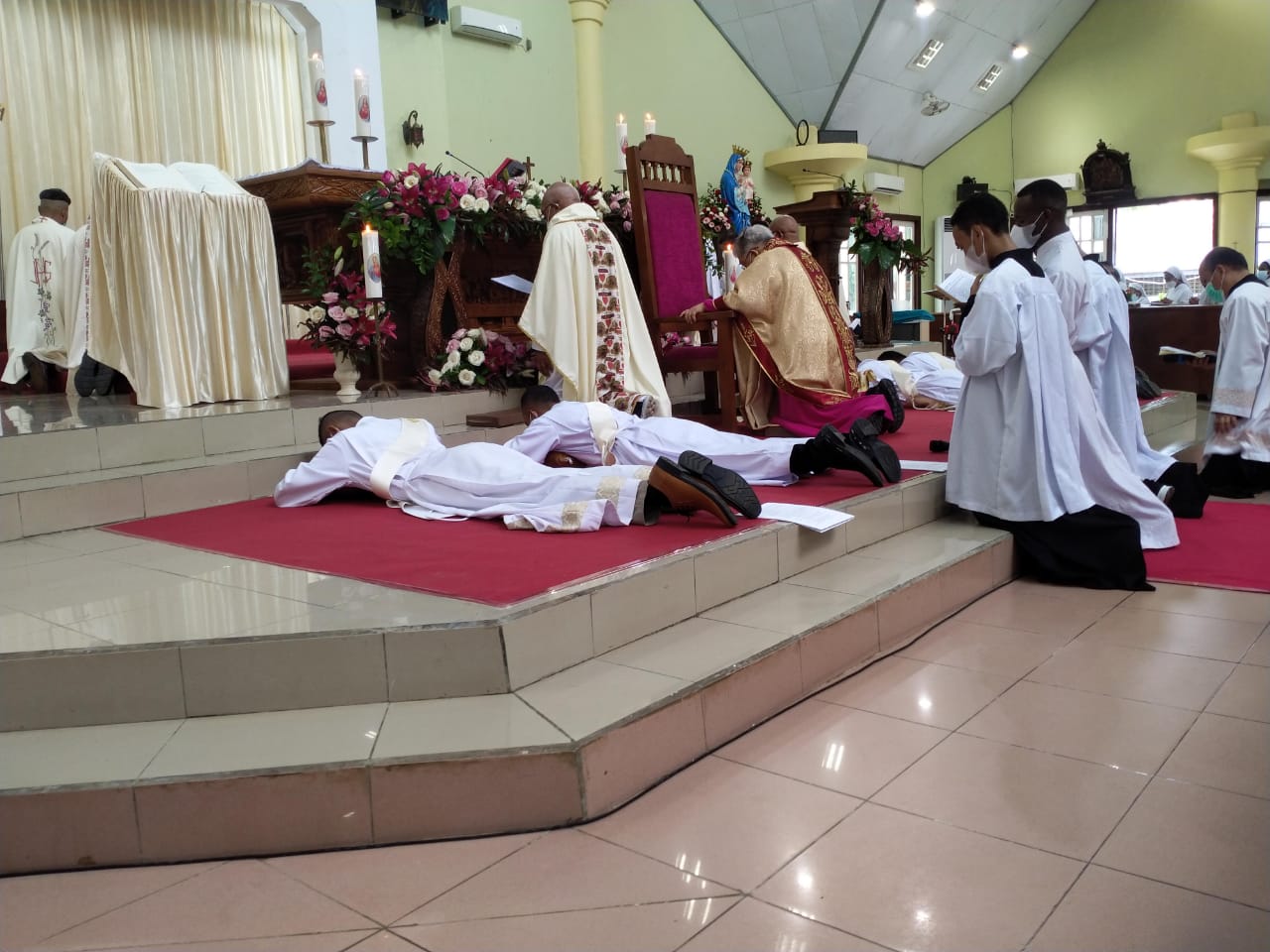 Keempat diakon yang telah ditahbiskan menjadi imam sedang tiarap di depan altar – Surya Papua/Frans Kobun