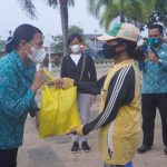 Ketua Tim Penggerak PKK Kabupaten Merauke, Ny. Imelda Carolina Mbaraka sedang menyerahkan sembako kepada salah seorang ibu penyapu jalan – Surya Papua/IST