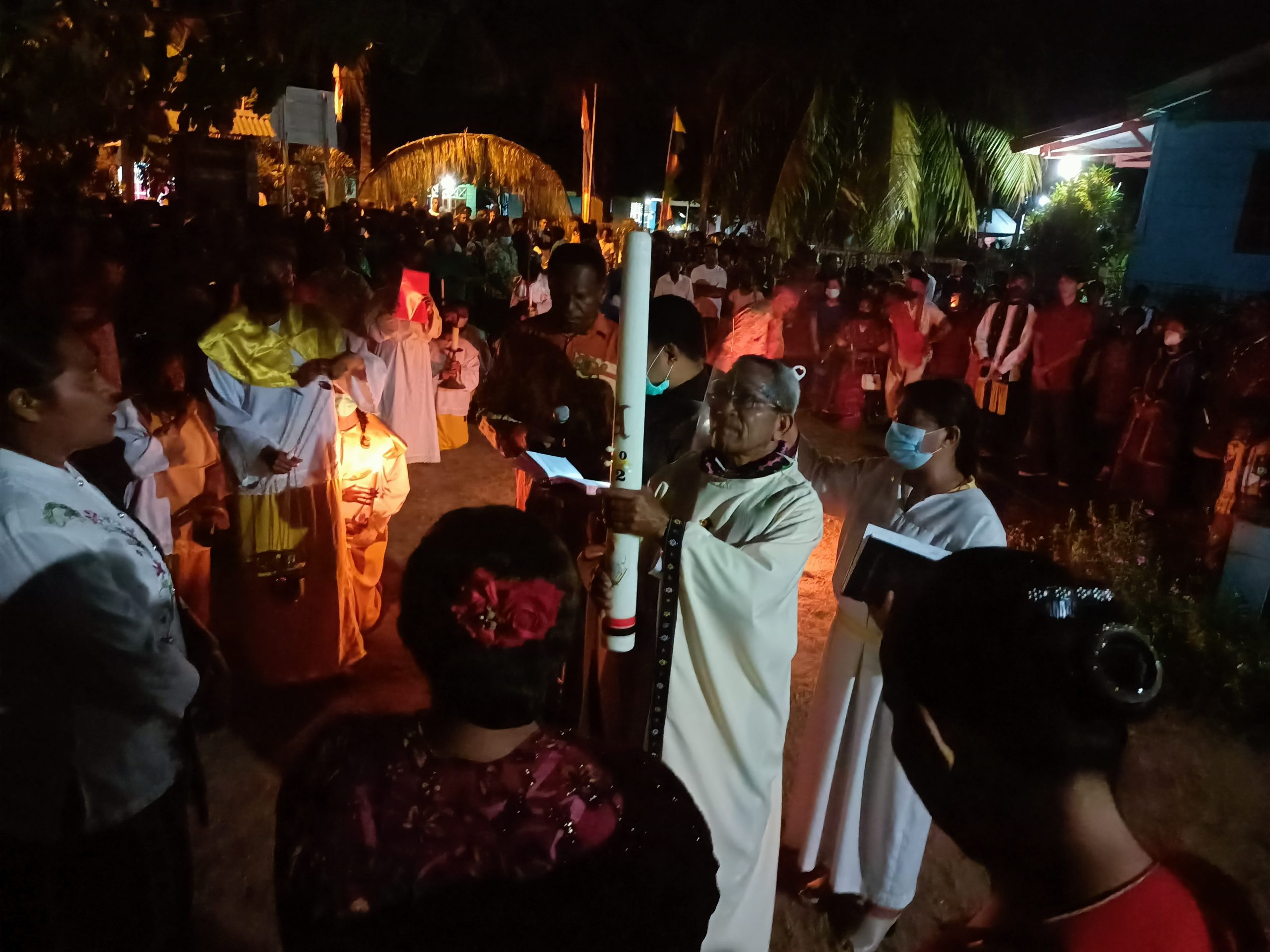 Pastor Pius Oematan sedang mengangkat Lilin Paskah setelah dibakar – Surya Papua/Frans Kobun