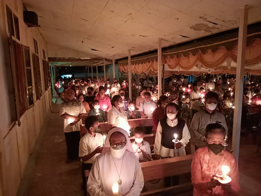 Umat sedang menyalahkan lilin yang dipegang di tangannya – Surya Papua/Frans Kobun
