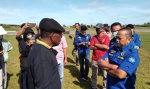 Simson Tiotra Mahuze, pemilik tanah Bandara Mopah sedang bicara dengan petugas bandara – Surya Papua/Yulianus Bwariat