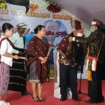 Bupati Merauke, Romanus Mbaraka sedang diselendangkan dalam syukuran imam baru – Surya Papua/Frans Kobun