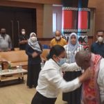 Salah seorang CPNS sedang mengenakan selendang NTT kepada Bupati Merauke, Romanus Mbaraka – Surya Papua/Yulianus Bwariat