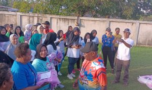 Bupati Merauke, Romanus Mbaraka sedang menyerahkan pakaian senam kepada perwakilan salah satu ibu – Surya Papua/Frans Kobun