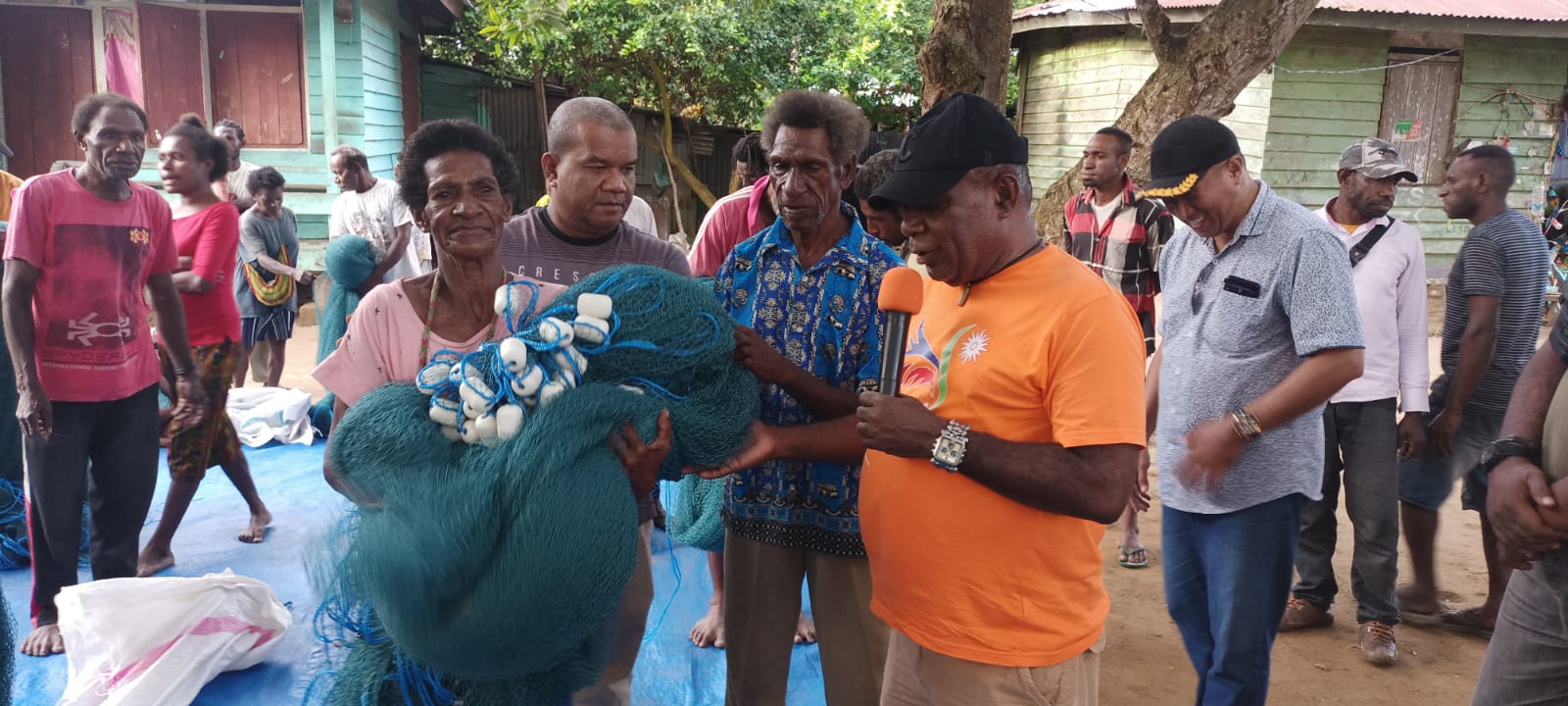 Bupati Merauke, Romanus Mbaraka sedang menyerahkan secara simbolis jaring kepada salah seorang mama Papua – Surya Papua