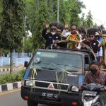 Bupati Merauke, Romanus Mbaraka saat berada di atas mobil bak terbuka ketika diarak keliling kota – Surya Papua/Frans Kobun