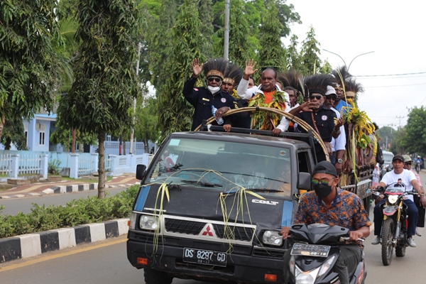 Bupati Merauke, Romanus Mbaraka saat berada di atas mobil bak terbuka ketika diarak keliling kota – Surya Papua/Frans Kobun