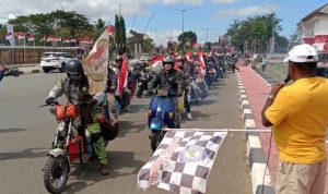 Bupati Merauke, Romanus Mbaraka sedang mengangkat bendera melepas bikers menuju Boven Digoel – Surya Papua/Yulianus Bwariat
