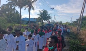 Perarakan oleh umat Katolik menuju Gereja Katolik Santa Theresia Buti pada peringatan masuknya Gereja Katolik di Papua Selatan – Surya Papua/Frans Kobun