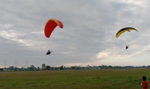 Pengibaran Bendera Merah Putih di udara dengan paramotor – Surya Papua/Yulianus Bwariat