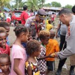 Kapolres Merauke, AKBP Sandi Sultan sedang berbagi dengan masyarakat termasuk anak-anak di Pintu Air, Kelurahan Maro – Surya Papua/IST