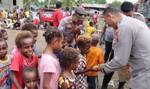 Kapolres Merauke, AKBP Sandi Sultan sedang berbagi dengan masyarakat termasuk anak-anak di Pintu Air, Kelurahan Maro – Surya Papua/IST