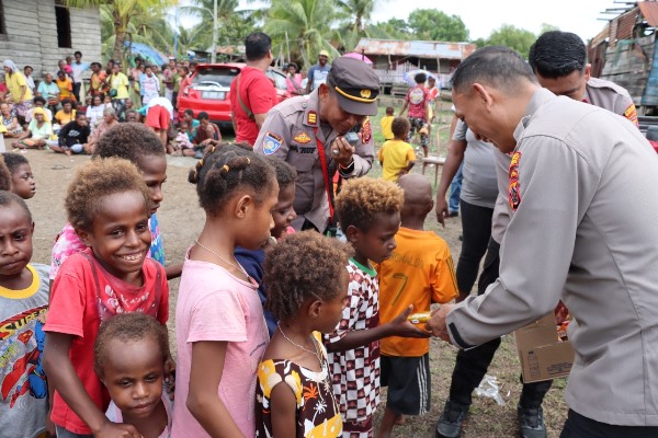 Kapolres Merauke, AKBP Sandi Sultan sedang berbagi dengan masyarakat termasuk anak-anak di Pintu Air, Kelurahan Maro – Surya Papua/IST