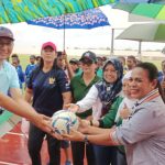 Kepala Dispora Kabupaten Merauke, Mike Walinaulik sedang menyerahkan bola kaki kepada Ketua Tim Penggerak PKK, Imelda Carolina Mbaraka dan selanjutnya diserahkan lagi kepada wasit – Surya Papua/Frans Kobun