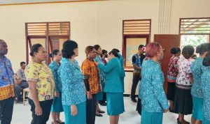 Ketua Tim Penggerak PKK Distrik Merauke, Ester Rudolf Corputty sedang menyematkan lambang kepada salah seorang pengurus – Surya Papua/Ichal Ukat