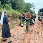 Seorang biarawati bersama Satgas yang memberikan penyelamatan ketuka mobil yang ditumpangi terjebak dalam lumpur – Surya Papua/IST