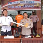 Kapolres Asmat, AKBP Agus Hariadi sedang menunjuk kampak yang digunakan pelaku membunuh dua orang – Surya Papua/Yulianus Bwariat