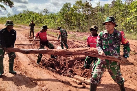 Beberapa anggota TNI sedang memindahkan kayu di tengah jalan yang dipalang – Surya Papua/IST