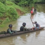 Prajurit Satgas-Pamtas sedang menggunakan perahu lesung menyeberang sungai Kombut untuk melakukan pemantauan patok perbatasan RI-PNG – Surya Papua/IST