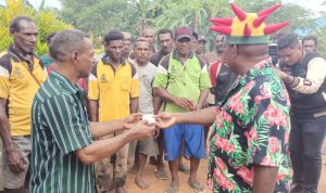 Bupati Merauke, Romanus Mbaraka sedang menyerahkan uang segar senilai Rp 10 juta kepada Kepala Kampung Senegi untuk masyarakat setempat – Surya Papua/Frans Kobun