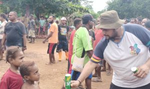 Anak-anak di Kampung Kaliki sedang antri untuk mendapatkan minuman kaleng – Surya Papua/Frans Kobun