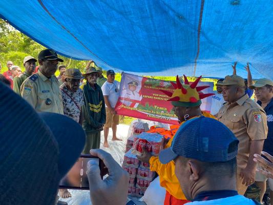 Bupati Merauke, Romanus Mbaraka menyerahkan minuman kaleng kepada perwakilan warga – Surya Papua/IST