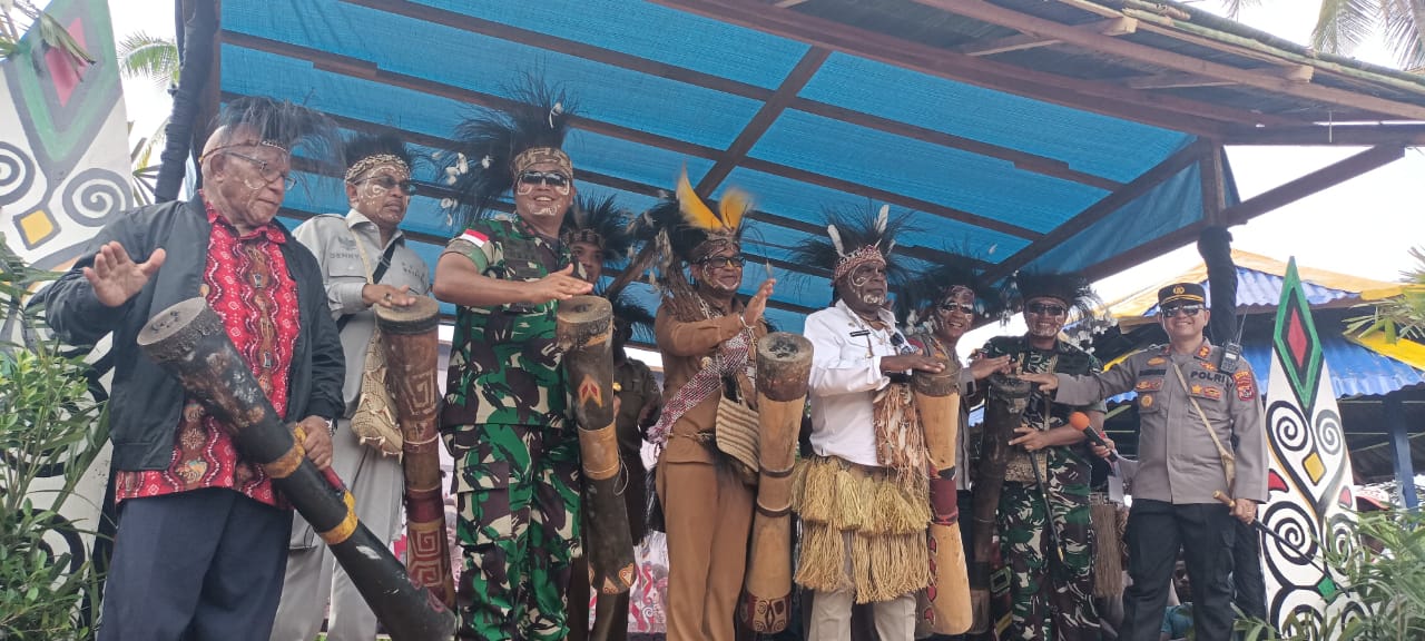 Penjabat Bupati Mappi, Michael Gomar bersama Bupati Merauke, Romanus Mbaraka sedang pukul tifa – Surya Papua/Frans Kobun
