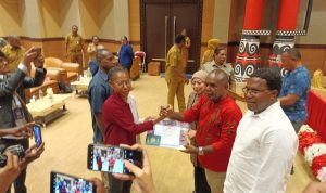 Penyerahan dokumen oleh Bupati Merauke, Romanus Mbaraka kepada dua perwakilan mahasiswa Marind yang akan kuliah ke luar negeri – Surya Papua/Yulianus Bwariat
