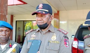 Kasatpol PP Kabupaten Mappi, Septianus Woniama dan stafnya foto bersama di depan kendaraan dinas milik pemda Mappi yang berhasil ditarik – Surya Papua/Yulianus Bwariat