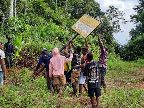 Papan sedang diangkat  oleh masyarakat bersama pihak perusahan untuk dipancangkan – Surya Papua/IST
