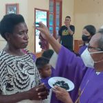 Pastor Pius Oematan, Pr sedang oleskan abu yang ditandai tanda Salib di umat – Surya Papua/Frans Kobun