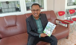 Ketua DPRD Merauke, Benjamin Latumahina sedang menunjuk buku hasil karyanya – Surya Papua/Yulianus Bwariat