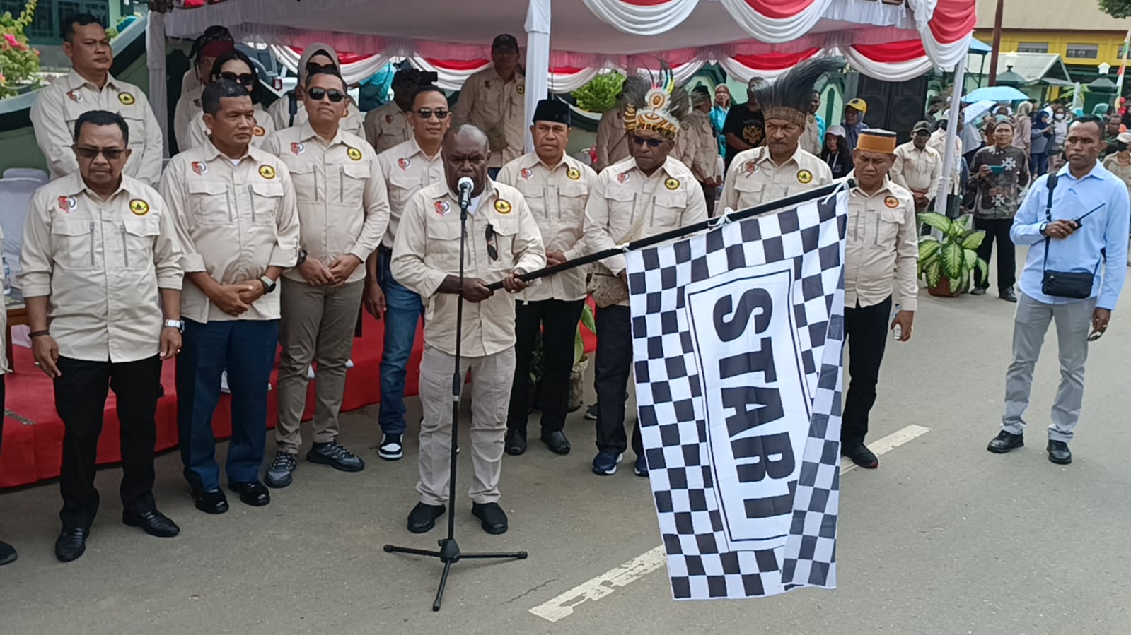 Bupati Merauke, Romanus Mbaraka mengangkat bendera melepas peserta pawai – Surya Papua/Yulianus Bwariat