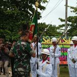Danrem 174/ATW, Kolonel (Inf) Agus Widodo sedang mencium bendera – Surya Papua/Yulianus Bwariat