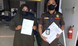 Juru sita pajak negara dan perwakilan kuasa wajib pajak sedang tunjukberkas berupa BA Sita – Surya Papua/IST