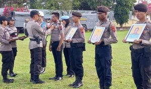 Kapolres Merauke, AKBP Sandi Sultan sedang membuka pakaian dinas salah satu anggota yang dipecat- Surya Papua/IST