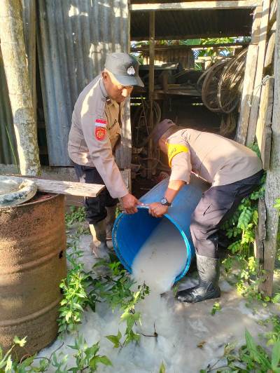 Ratusan liter sagero yang diamankan dan dituangkan ke tanah oleh aparat kepolisian di Polsek Onggaya – Surya Papua/IST