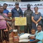 Masyarakat sedang foto bersama usai menerima bantuan sembako – Surya Papua/IST
