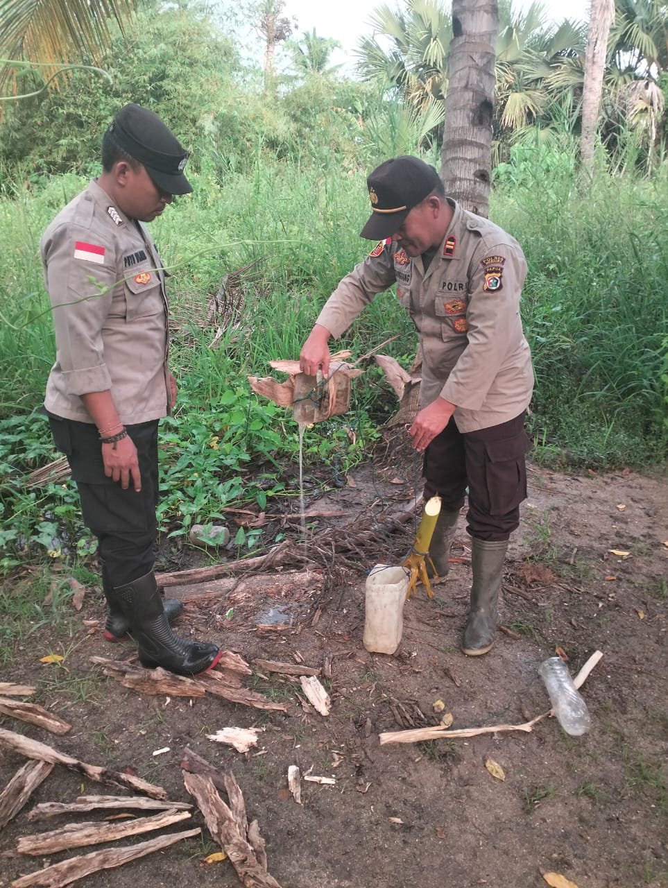 Kapolsek Onggaya, Iptu J Sitanggang bersama anggotanya sedang menuangkan sagero ke tanah – Surya Papua/IST