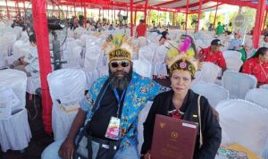 Sabina Weab didampingi suaminya sedang menunjuk satya lencana serta piagam penghargaan yang diterimanya – Surya Papua/Frans Kobun